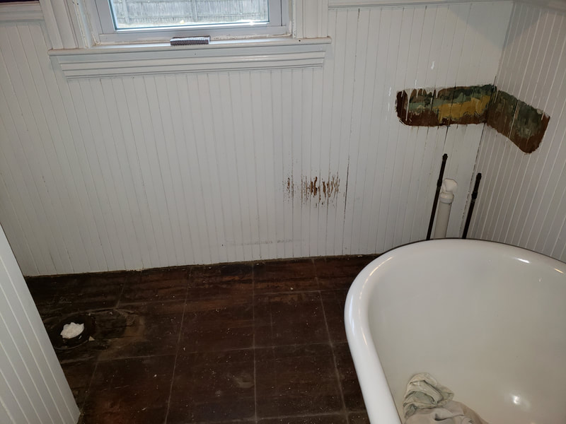Old bathroom with clawfoot tub and outdated flooring