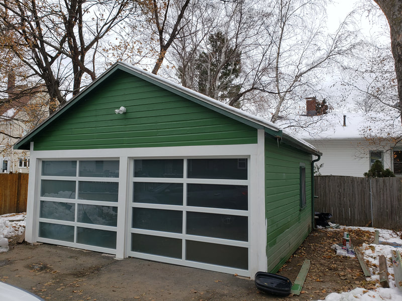 Green two door garage with white trim finished remodel