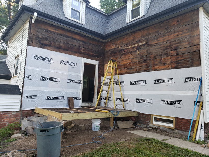 Porch construction landing with raw siding
